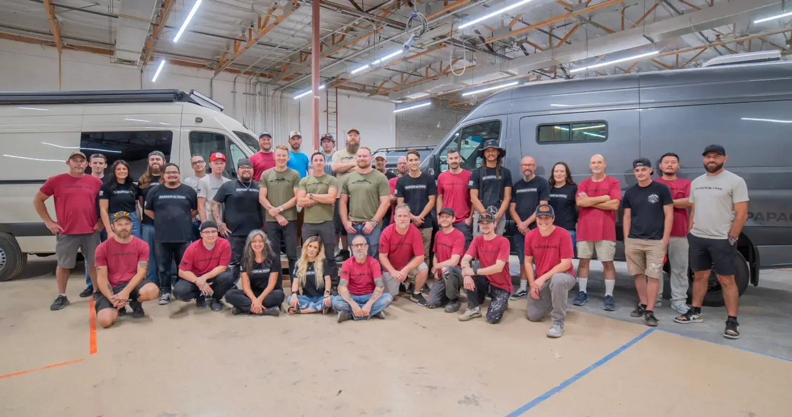The Papago Vans crew in the Mesa shop, in front of a row of Sprinters under build