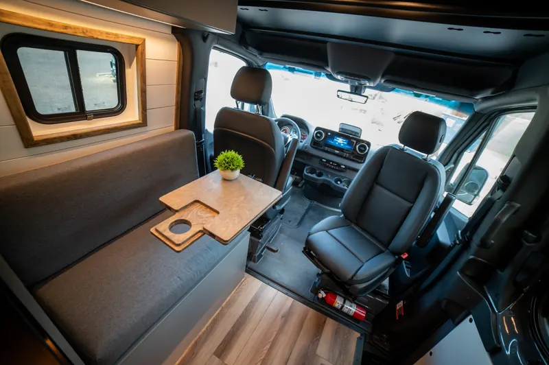 Bench dinette with a folding table beside the swivelled cab seats