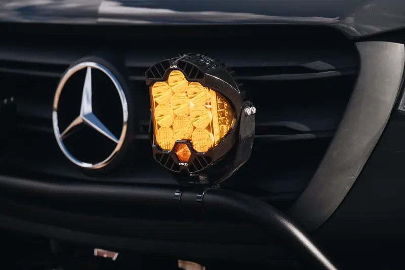 An amber off-road light mounted beside the Mercedes star on a Papago Sprinter's grille